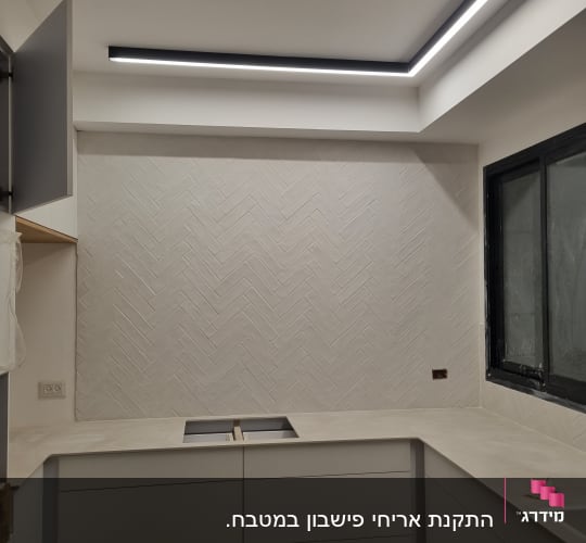 מטבח בשיפוץ עם אריחים חדשים על הקיר